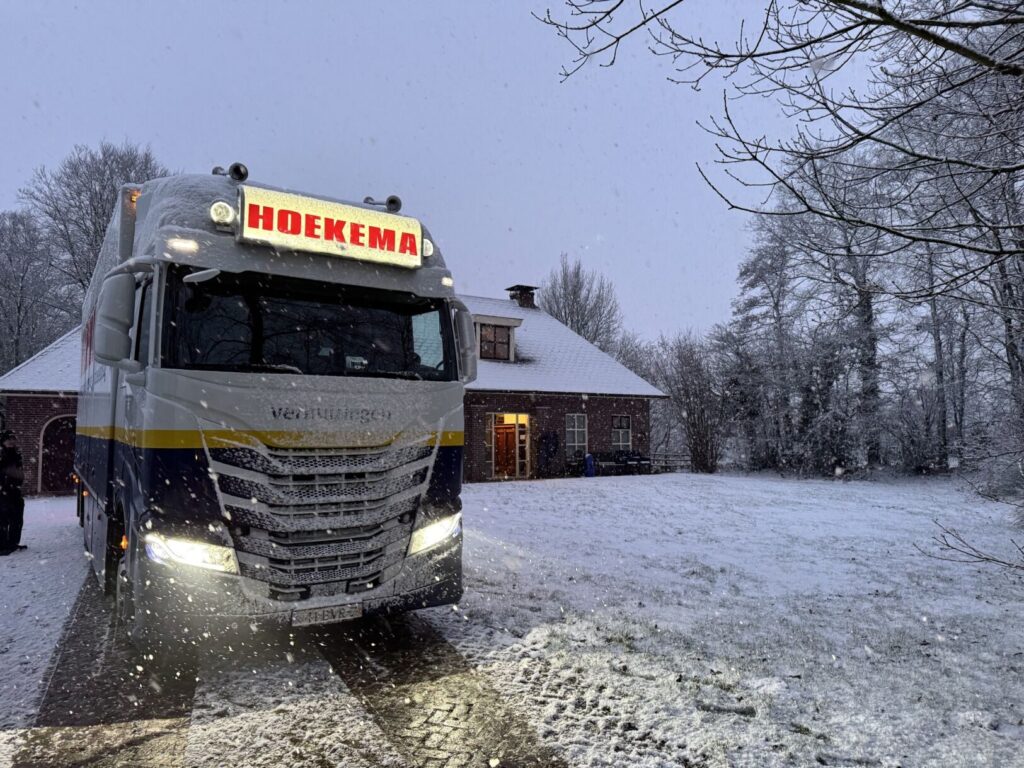 Verhuiswagen bij een Nederlandse boerderij in de sneeuw