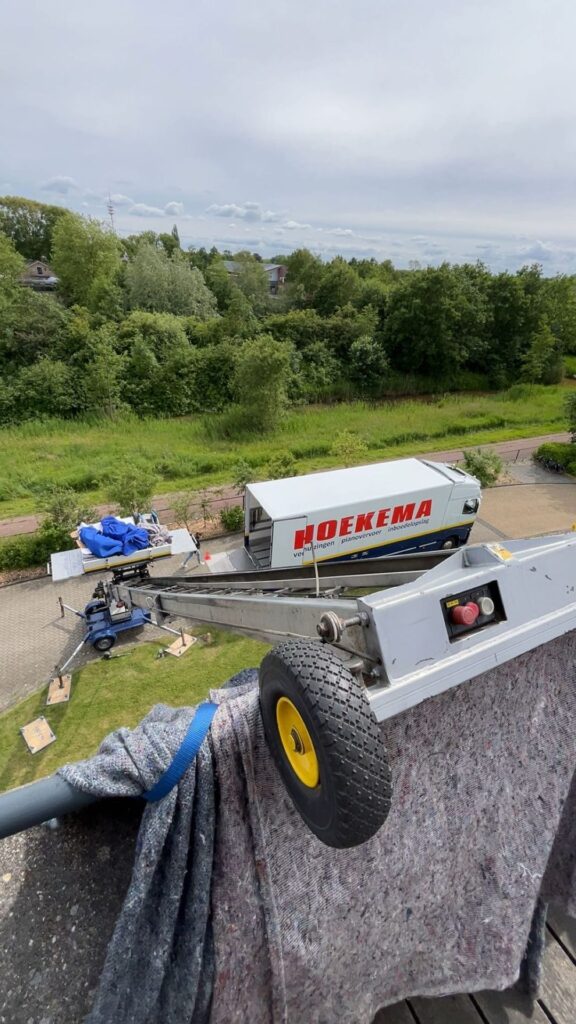 Verhuizer aan de verhuislift bij een balkon