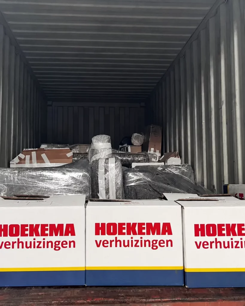 Zeecontainer wordt beladen met verhuisdozen