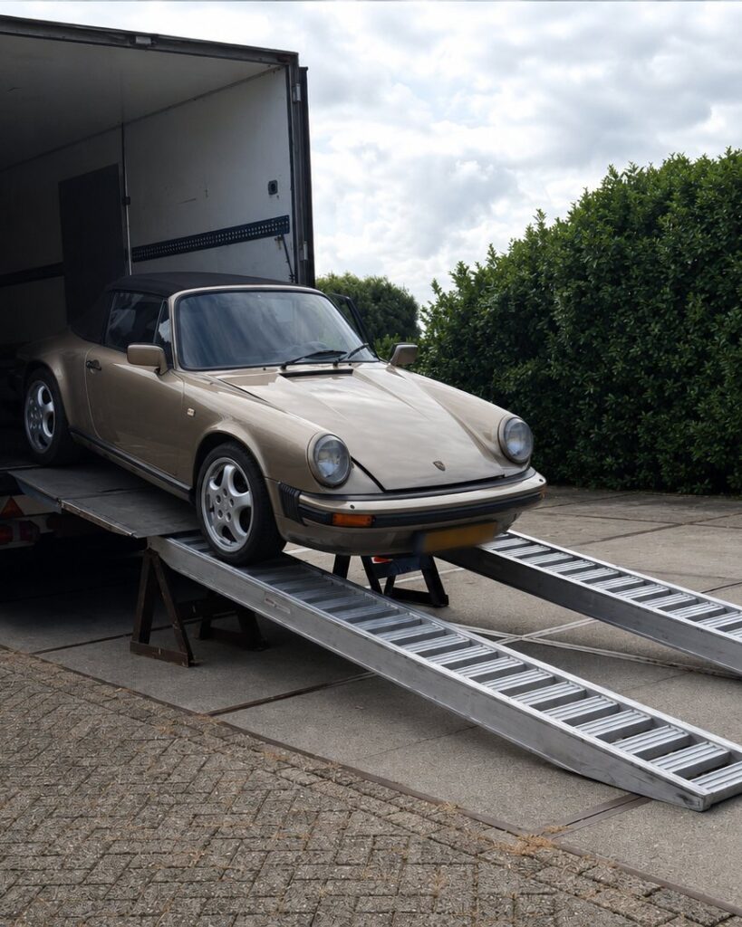 Auto wordt via oprijplaten in de wagen gereden