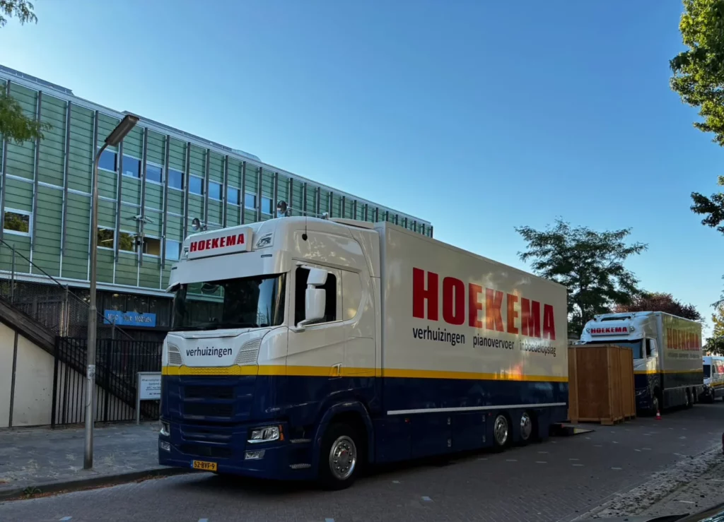 Twee verhuiswagens van Hoekema Verhuizingen bij een kantoorverhuizing