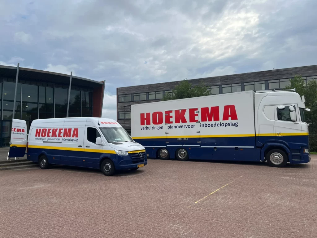 Verhuiswagen en verhuisbus van Hoekema Verhuizingen bij een kantoorpand